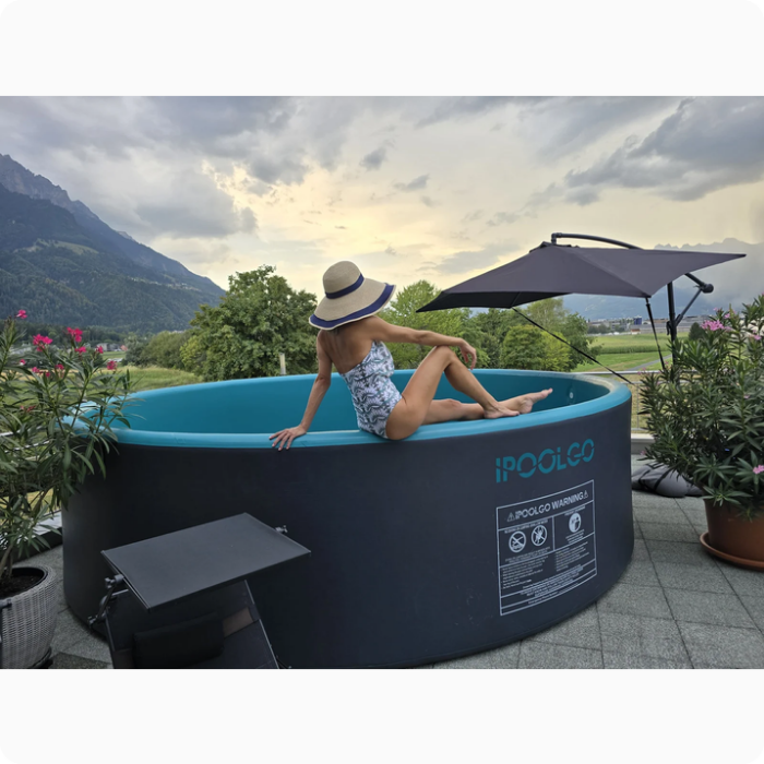 Runder iPoolGo Pool auf einer Terrasse mit Bergblick und einer Frau auf dem Poolrand